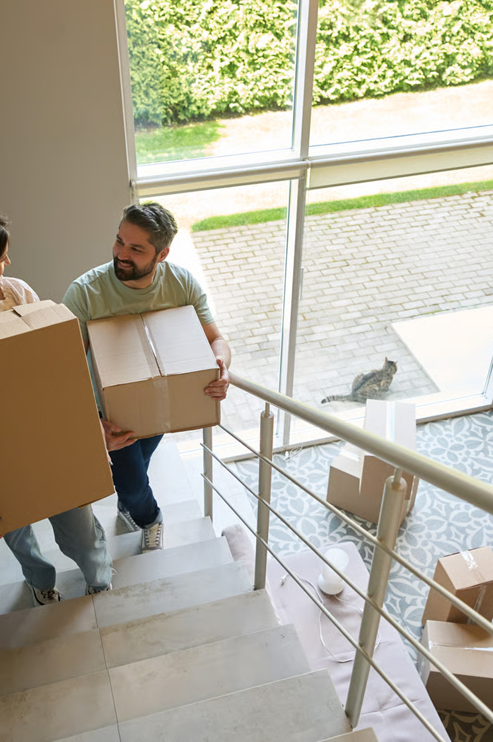 Young couple walking up stairs with boxes